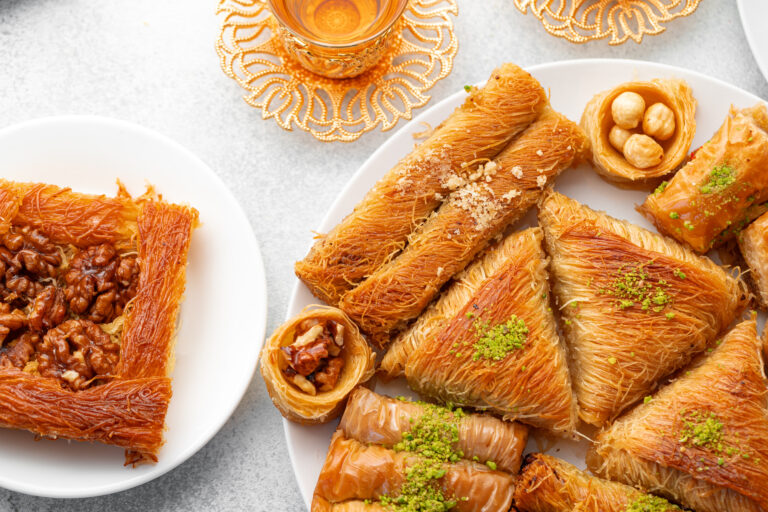 Various Turkish sweets and cup of tea on white textured background